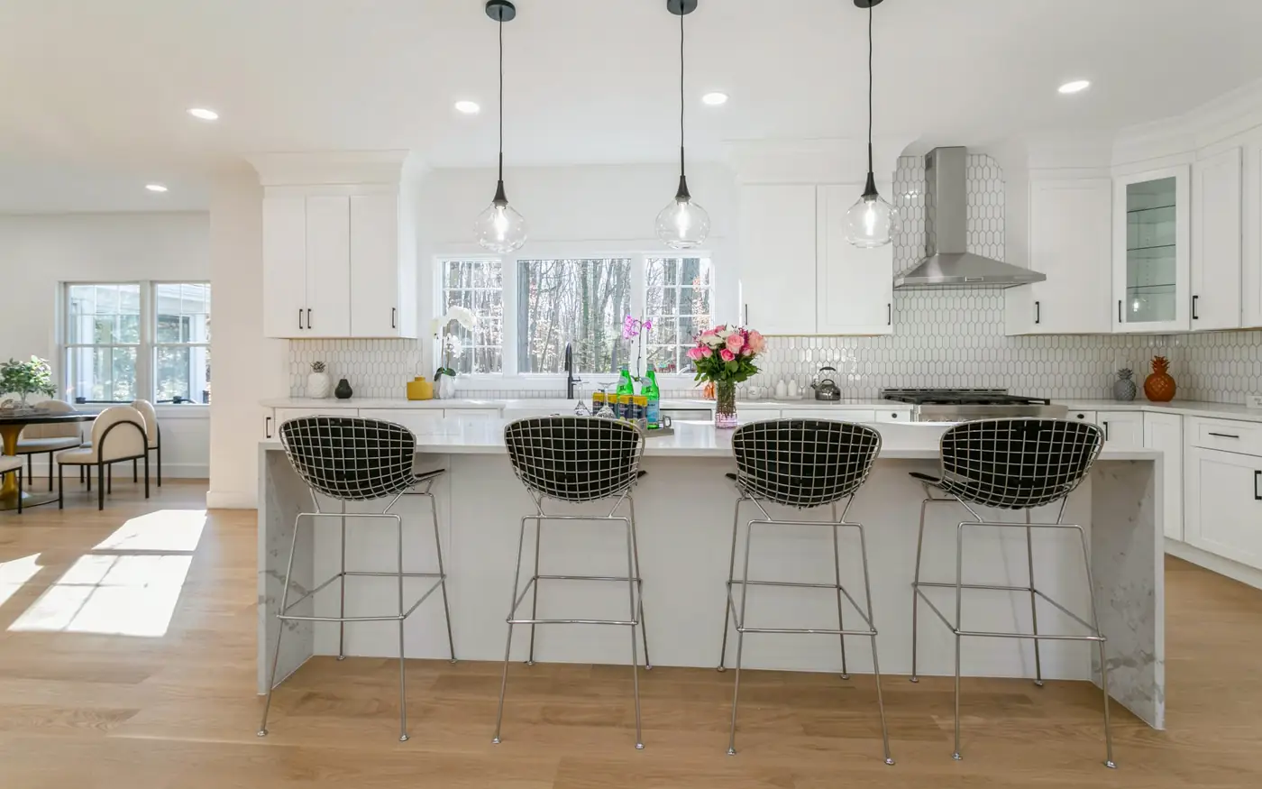 White kitchen with waterfall island and pendant lighting in a new custom home in Ridgewood, NJ