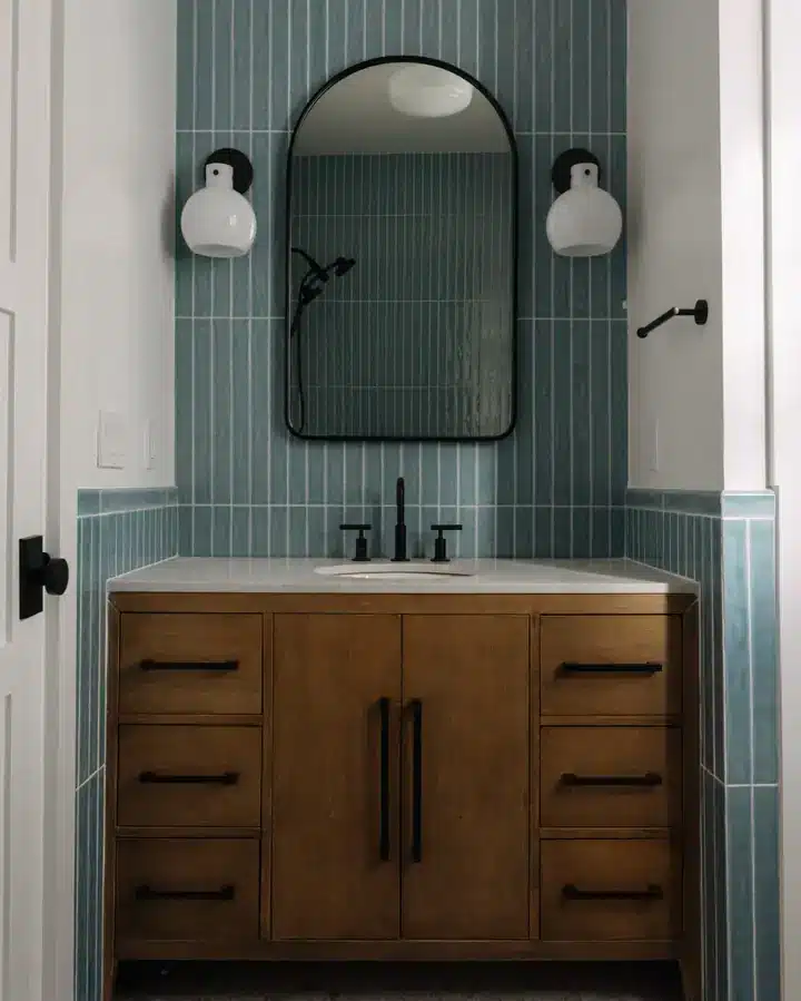 Bathroom vanity with blue vertical tile and arched mirror — The Columbia Project
