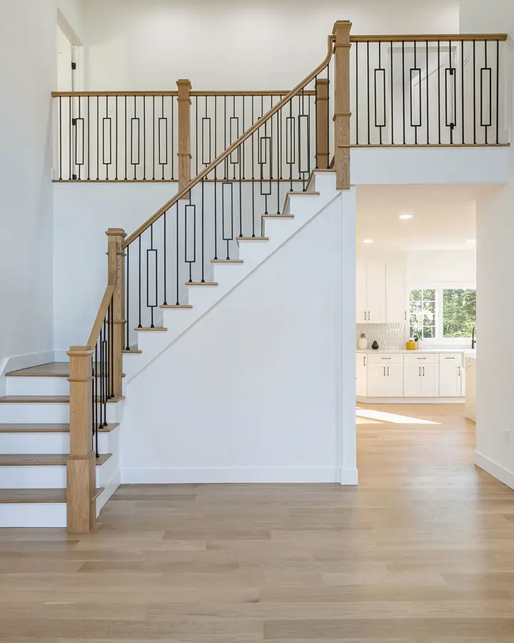 Two-story foyer with an oak and iron staircase in a new custom home in Ridgewood, NJ